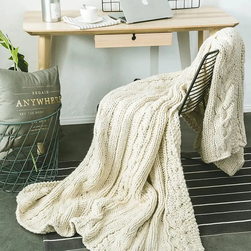 Beige chunky knit tassel throw blanket with cream cable pattern draped over black wire chair for decorbites beige chunky decor