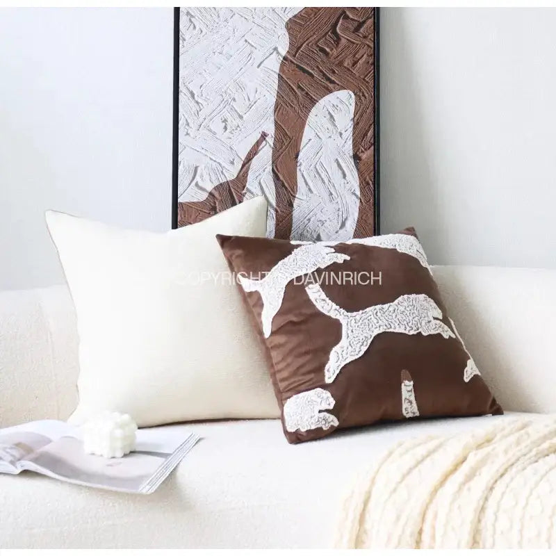 Brown velvet pillow with white embroidered dog design paired with beige convex rings geometry jacquard cushion cover