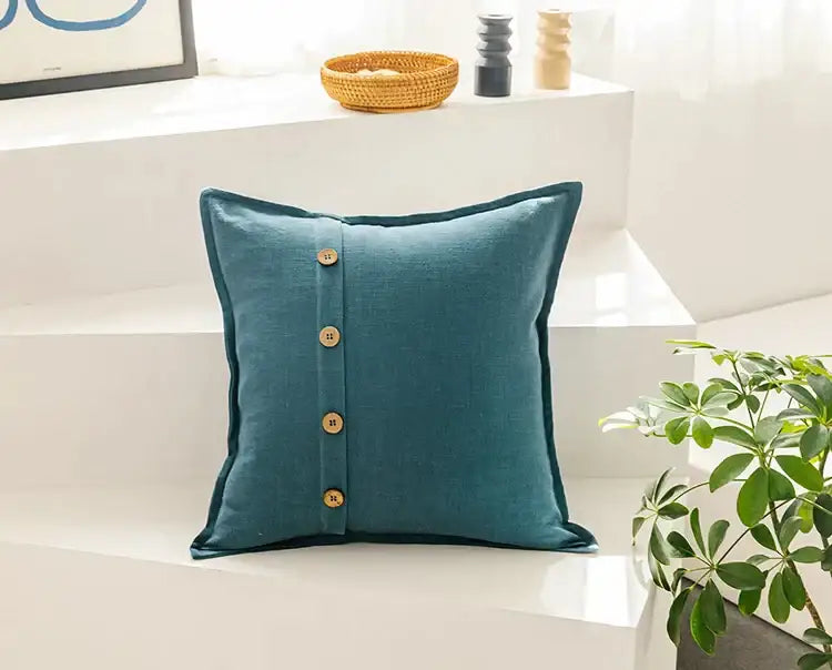 Teal linen throw pillow with four brass buttons down the front complementing beige cotton linen cushion cover decorbites cotton linen cushion