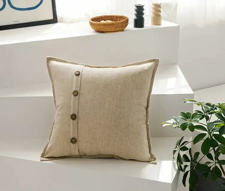 Beige cotton linen cushion cover with vertical row of four dark brown buttons for living room decor by decorbites