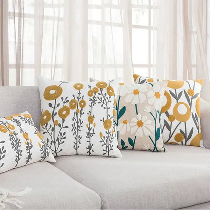 Set of four pillow covers with decorbites daisy floral geometric patterns in mustard yellow white and teal on soft fabric