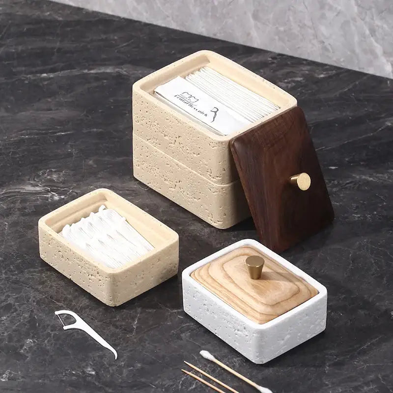 Beige and dark wood double decker natural stone jewelry organizer with textured concrete base holding dental floss packets