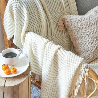 Beige decorbites 3d knitted tassel blanket with textured ribbed pattern and cream-colored knitted tassel fringe decor throw