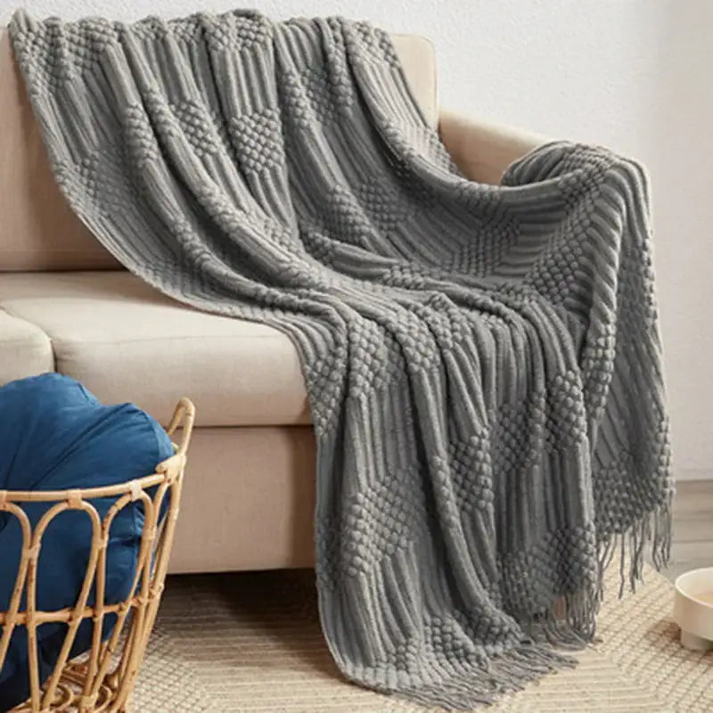 A cozy gray knitted tassel blanket with a ribbed pattern and fringe detailing by decorbites 3d knitted