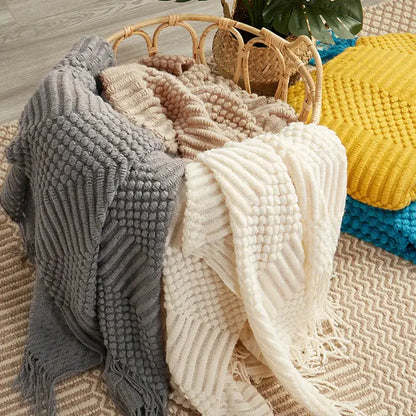 A cozy soft gray decorbites 3d knitted tassel blanket with ribbed pom-pom pattern perfect for bedroom throw decor