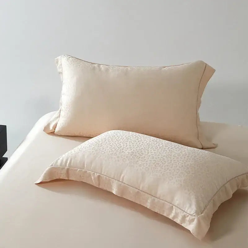 Cream-colored satin pillowcases with subtle leopard jacquard pattern and stitched edges from decorbites bedding set