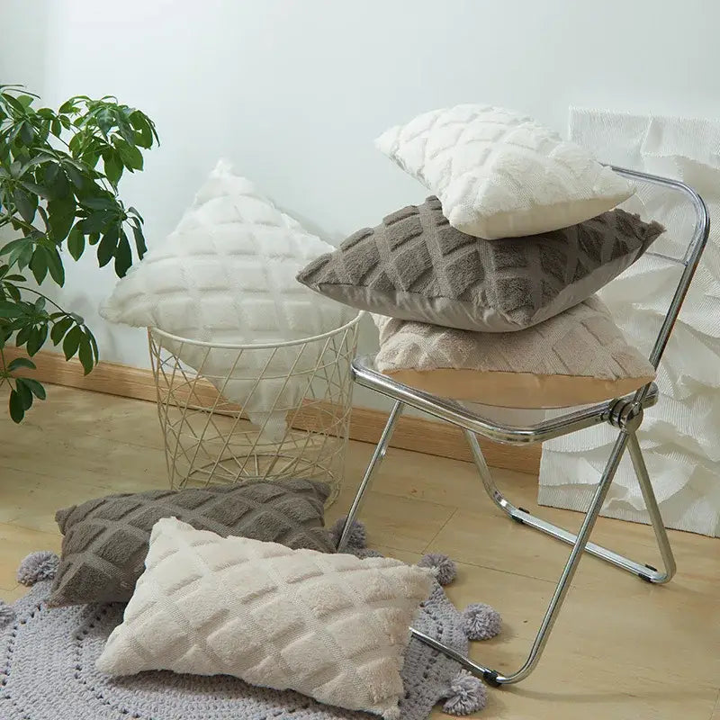 Stack of plush beige and gray cushion covers with a soft quilted geometric diamond pattern for living room decor