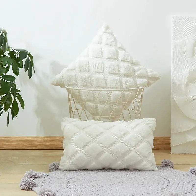 White quilted throw pillows with soft textured fabric and pom-poms complement beige and gray geometric diamond cushion cover