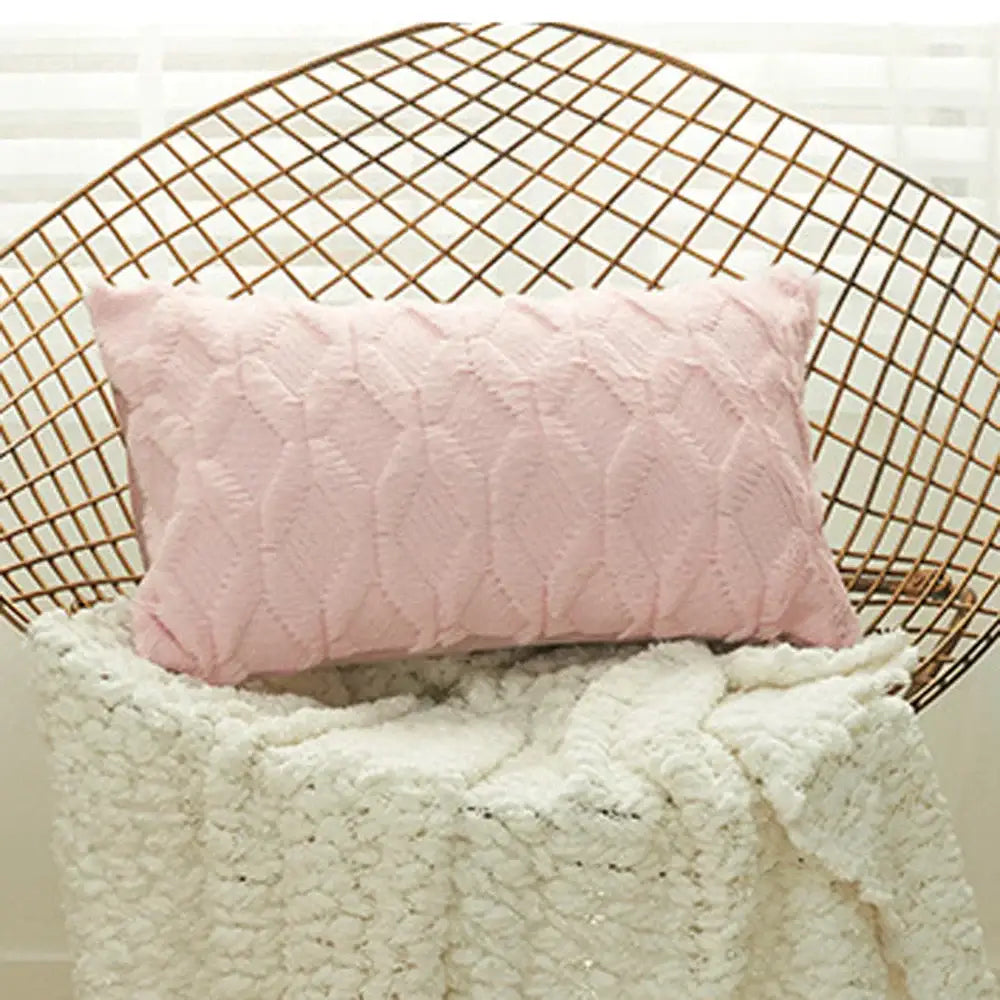 A soft pink cushion cover with a textured geometric diamond pattern ideal for living room decor