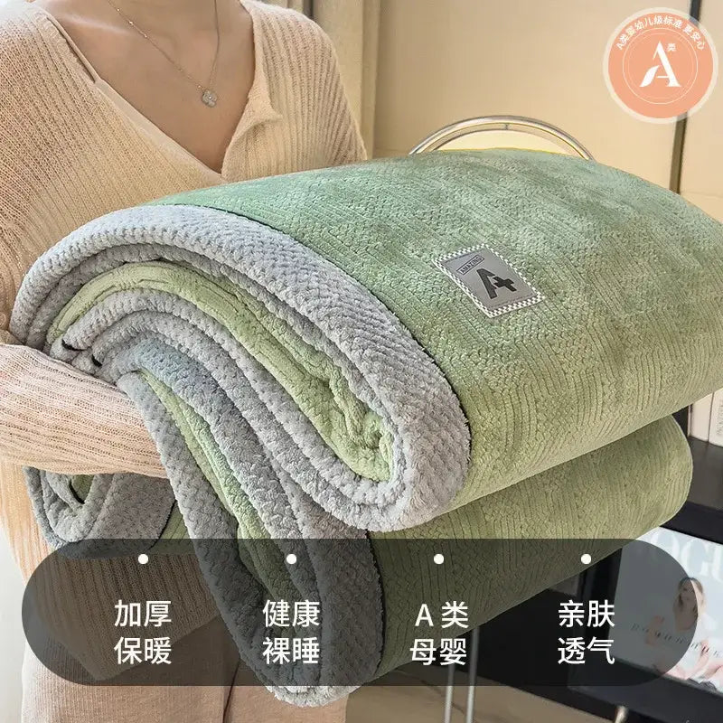 A soft plush green and gray velvet plush cotton blanket with textured surface and branded patch for bedroom throw