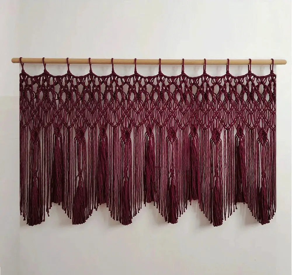 Maroon decorbites handwoven macrame wall hanging with intricate knotwork and tassels on a light wood rod for living room decor