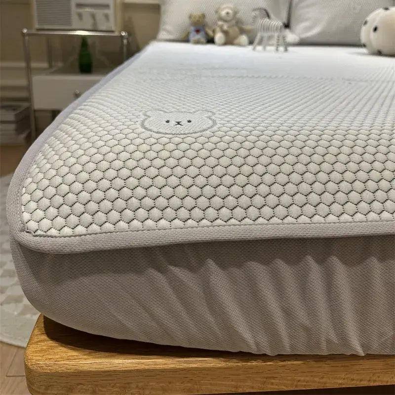 Beige honeycomb sheet set with decorbites cooling ice technology featuring a stitched bear face mattress protector