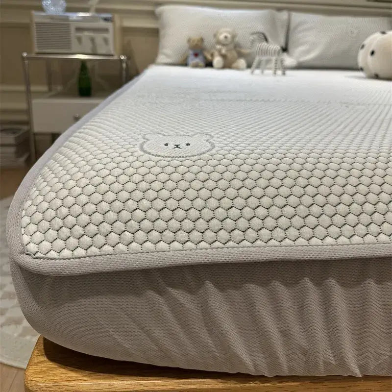 Beige honeycomb sheet set with ice bean cooling ice material and subtle embroidered bear face decorbites design