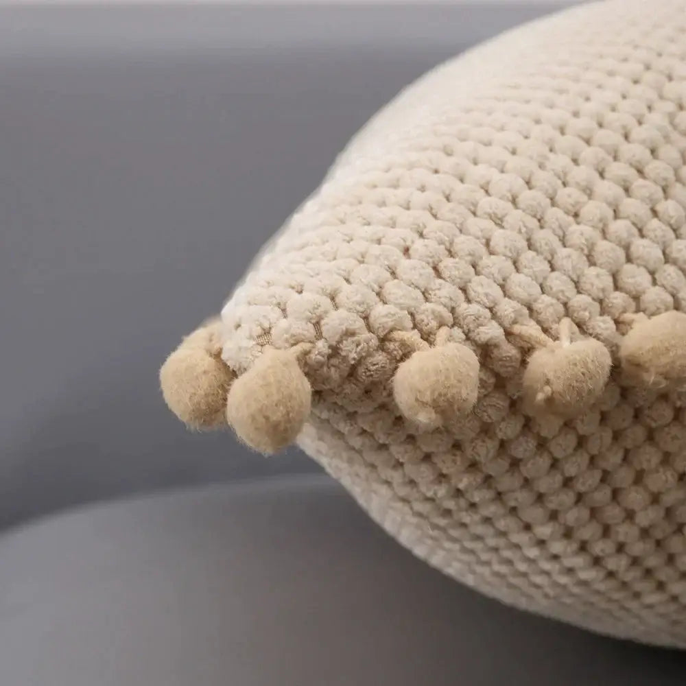 Beige knitted decorative pillow cover with textured rounded pom-poms perfect for living room decor
