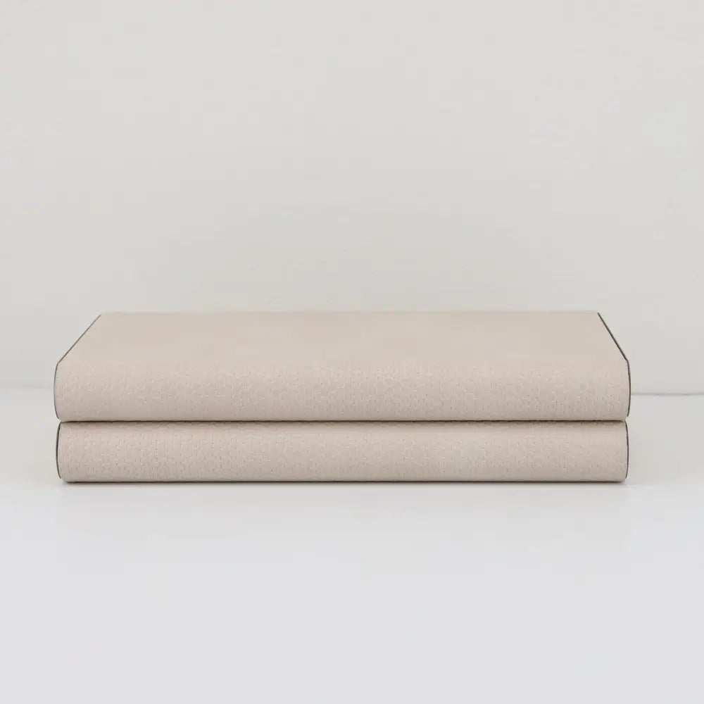 A beige leather jewelry box storage container with textured light beige leather and dark binding edges by decorbites