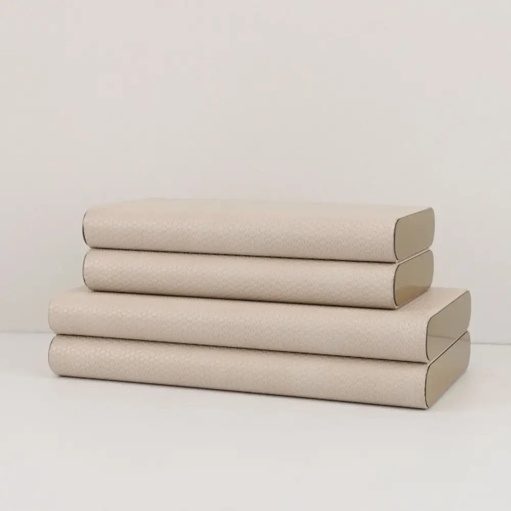 Stack of four beige leather jewelry box storage containers with textured covers and silver hinges by decorbites beige leather