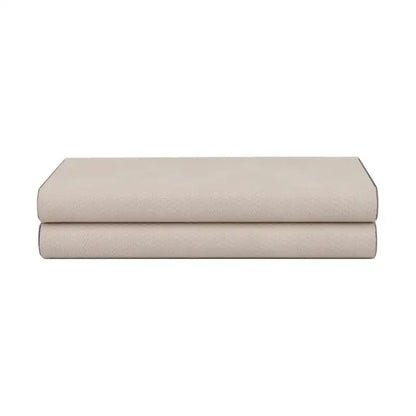 A beige leather jewelry box storage container with silver hinges is shown on neatly folded beige cotton bed sheets