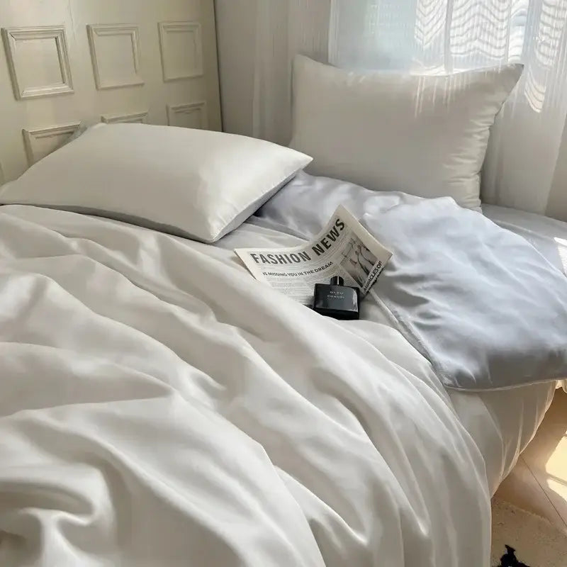 White satin duvet cover with matching pillowcases draped on bed from decorbites ice silky solid bedding set
