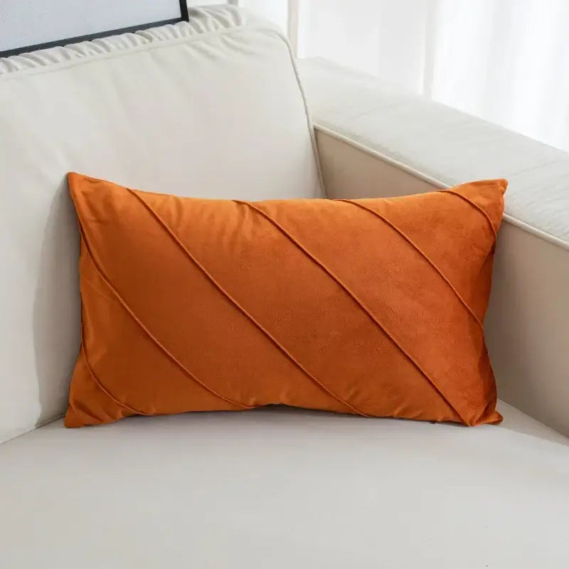 A rectangular orange velvet pillow with diagonal hand pleat embroidered design for living room decor