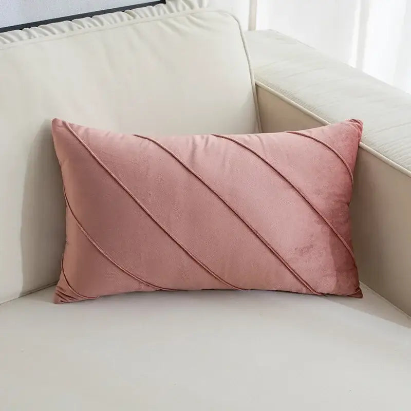 A soft pink velvet rectangular pillow with diagonal hand pleat embroidered stitching for living room use