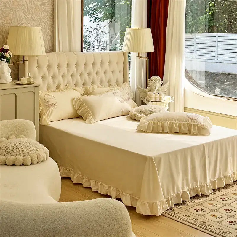 Cream-colored tufted bed with beige pink lace embroidery bedding set and decorbites beige pink ruffled pillows