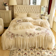 Cream-colored floral embroidered bedding set with ruffled edges and tufted headboard from decorbites beige pink lace collection