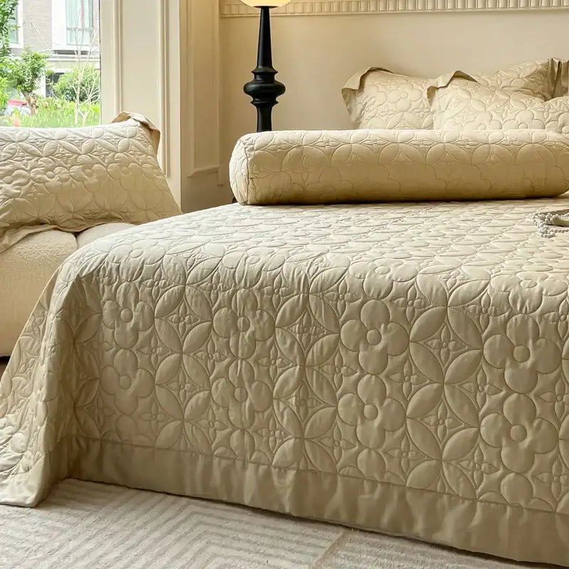Beige quilted eucalyptus fiber bedspread with raised floral pattern and ruffled edges for elegant bedroom decor