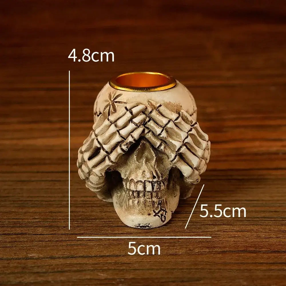 Beige resin bone skeleton candlestick holder with detailed hand-over-eyes design and gold-rimmed opening for decorbites bone skeleton decor
