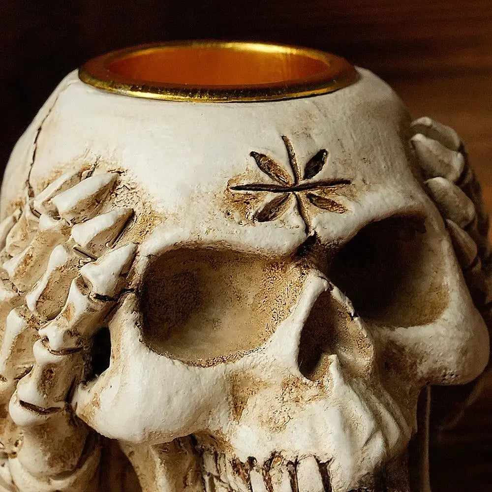 Beige resin bone skeleton candlestick holder with white textured skull, gold rim, and engraved leaf decorbites bone skeleton decor
