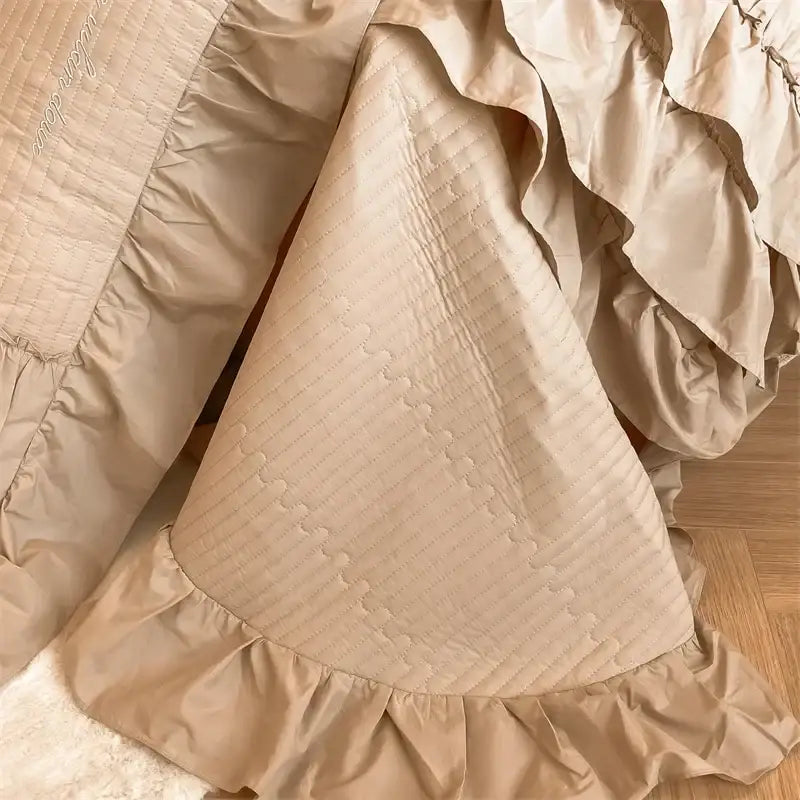 Beige quilted bed skirt with ruffled edges and diagonal stitching from decorbites cake layers cotton duvet set