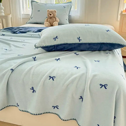 Beige scalloped cozy coral fleece blanket with light blue plush fabric navy blue embroidered bow decorbites cozy coral fleece