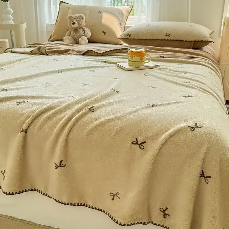 Beige scalloped cozy coral fleece blanket with brown embroidered bow patterns perfect for bedroom decorbites cozy coral use