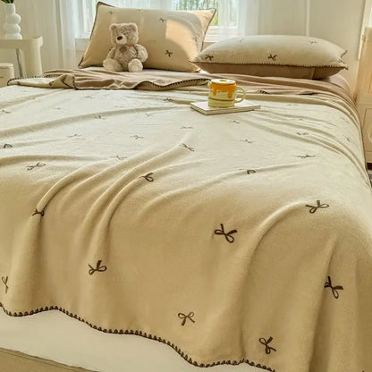 Beige scalloped cozy coral fleece blanket with brown embroidered bow patterns perfect for bedroom decorbites cozy coral use