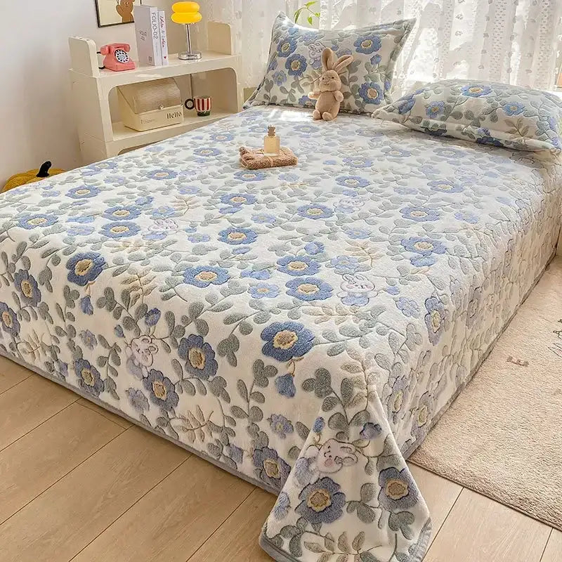 A cozy cartoon flannel blanket with soft blue and gray embroidered floral pattern used as a sofa cover from decorbites cartoon flannel