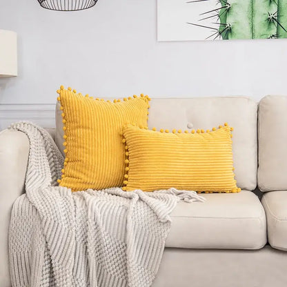 Two mustard-yellow corduroy throw pillows with pom pom trim matching decorbites beige striped cushion cover
