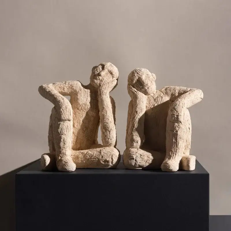 Two beige textured abstract resin figurine sculptures of seated figures for living room decor by decorbites