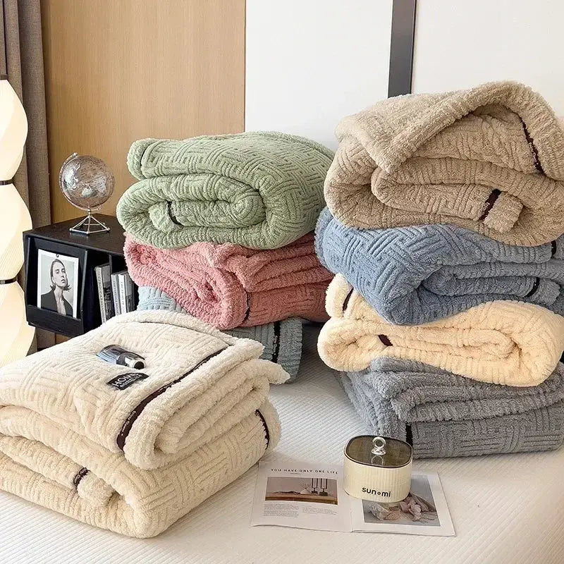 Stack of decorbites cozy fluffy fleece blankets in pastel hues including beige textured fluffy fleece with trim