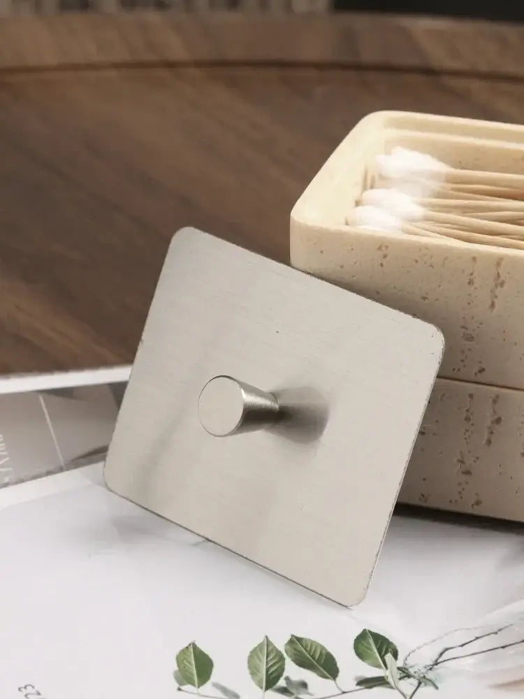 Stainless steel square wall hook with rounded knob on beige textured natural stone double decker jewelry organizer