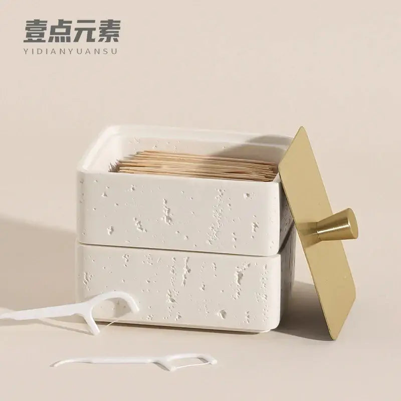Beige textured natural stone double decker jewelry organizer with white ceramic toothpick holder and gold metal lid