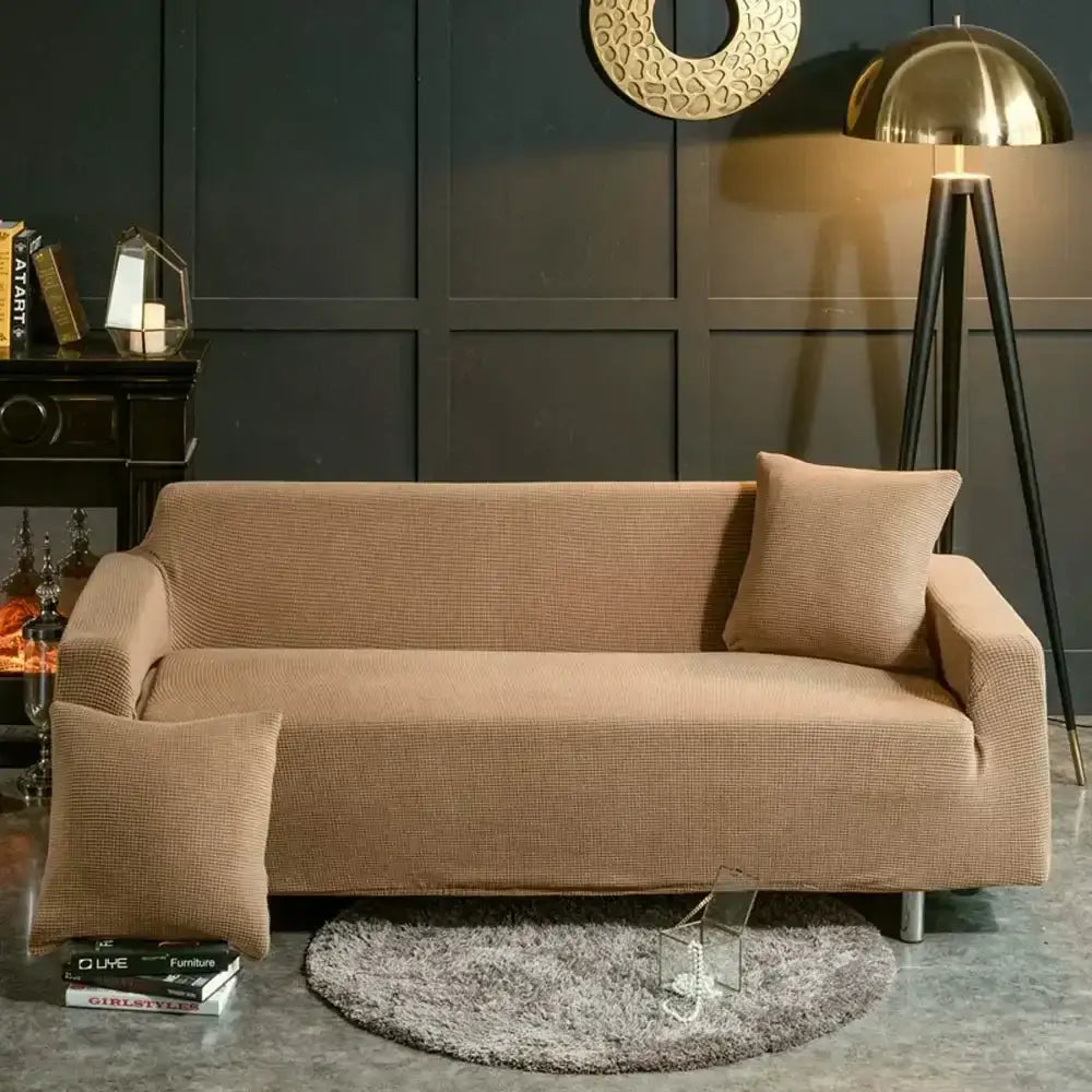 Beige textured quilted sofa cover with pillows snugly fitted over a modern three-seater living room couch decorbites 3d quilted sofa cover