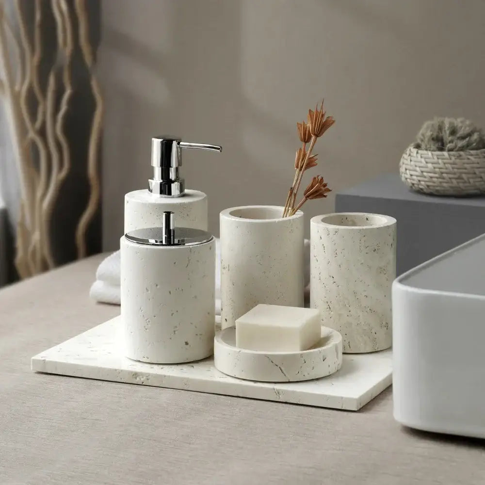 Beige travertine marble bathroom set with cream-colored speckled stone and chrome pump dispensers by decorbites