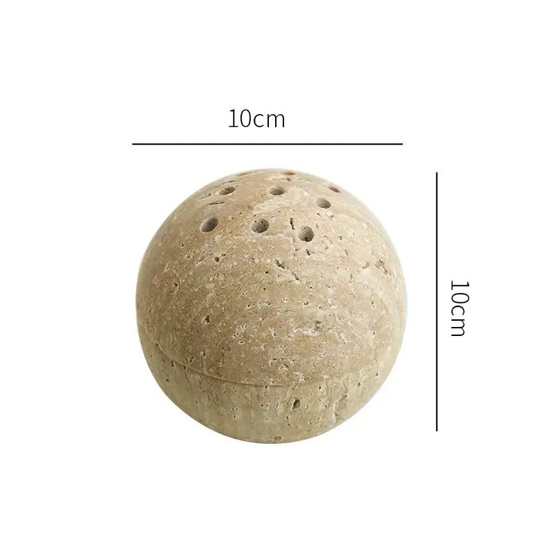 Beige travertine marble sphere incense burner made of textured stone with perforations for living room decor by decorbites