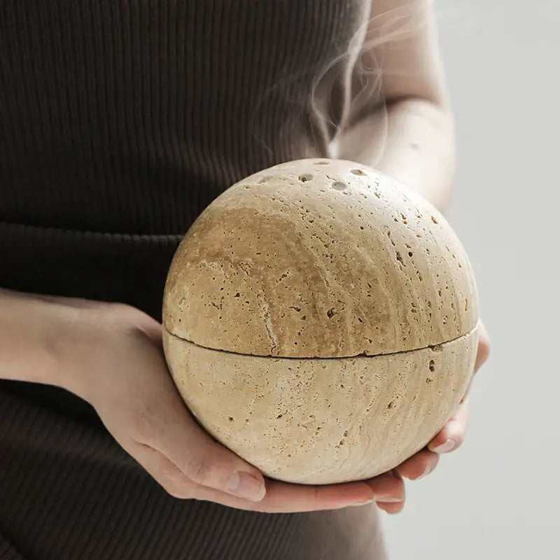 Beige travertine marble incense burner with textured sphere design and small perforations for living room decorbites decor