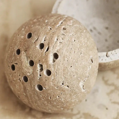 Beige travertine marble incense burner with textured stone and circular holes for living room decor by decorbites