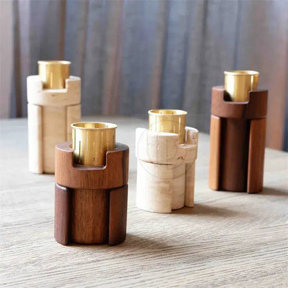 Modern minimalist essential oil burner with dark wood candle holders, beige travertine tray, and polished brass inserts