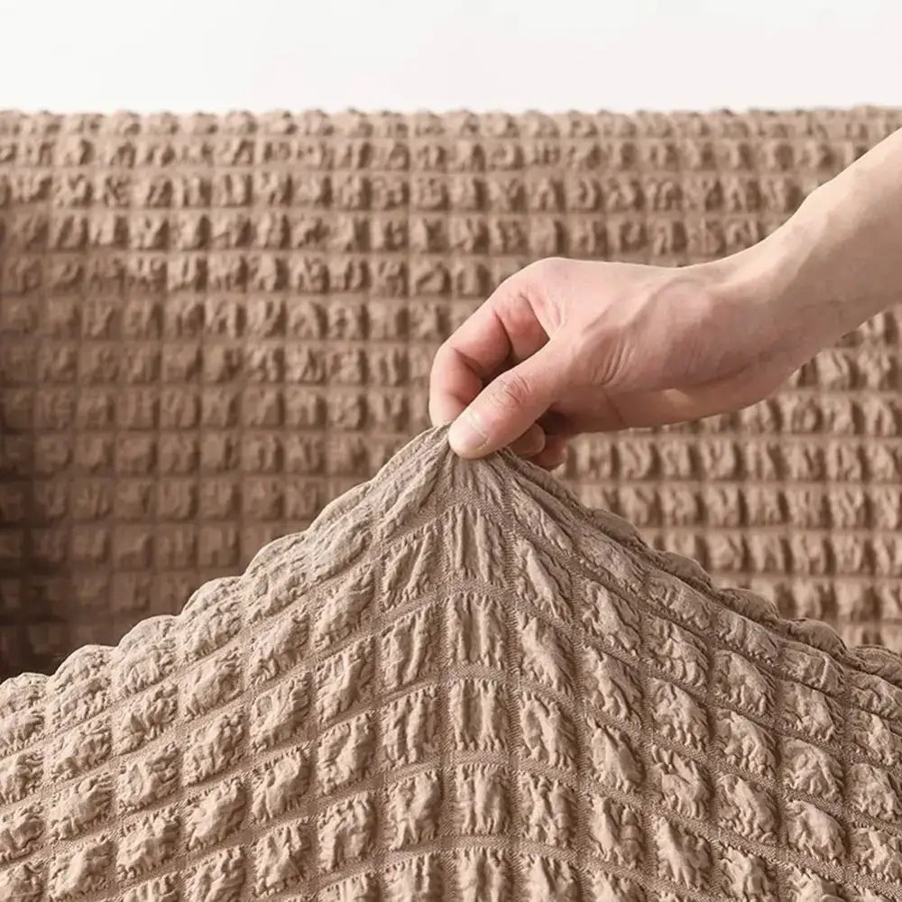 Beige textured stretch sofa cover with quilted grid pattern featuring a cozy solid color design for living room use