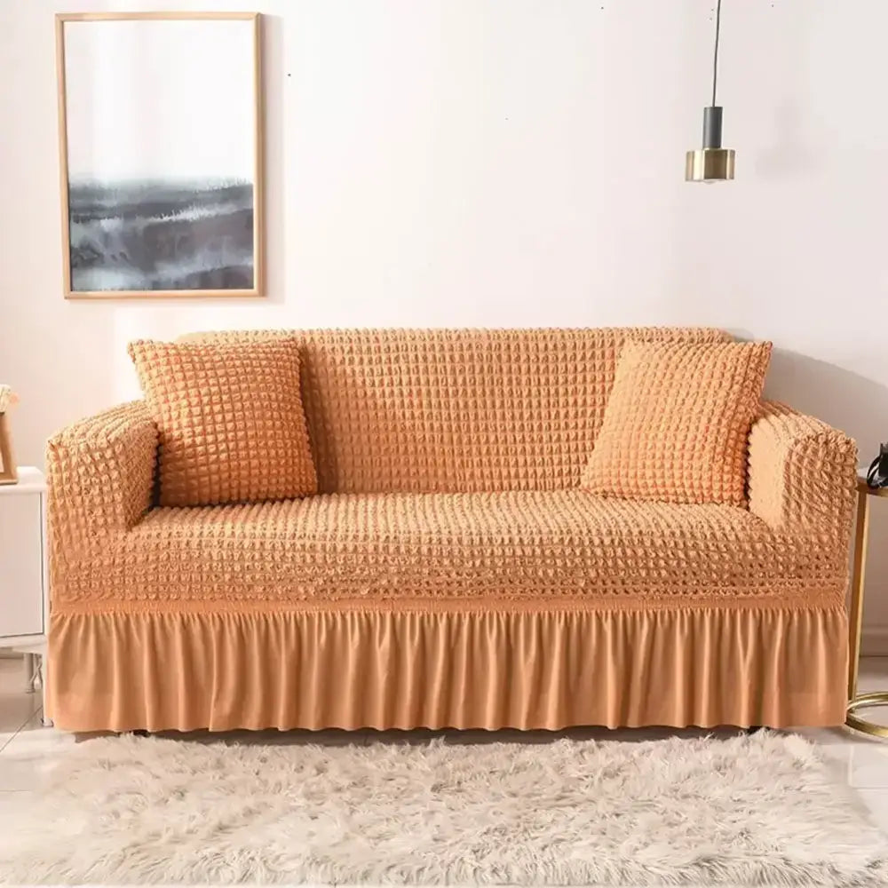 Orange textured cozy sofa cover with ruffled hem and matching pillows for a beige waffle cozy sofa slipcover