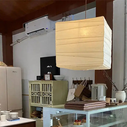 Beige and white cube rice paper pendant lamp by decorbites hanging from a cord for living room decor