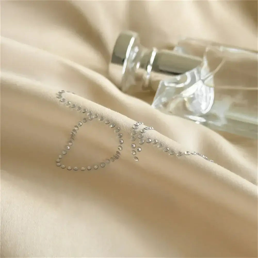 A beige and white hot diamond lace bedding set featuring a delicate silver rhinestone o embellishment on satin fabric