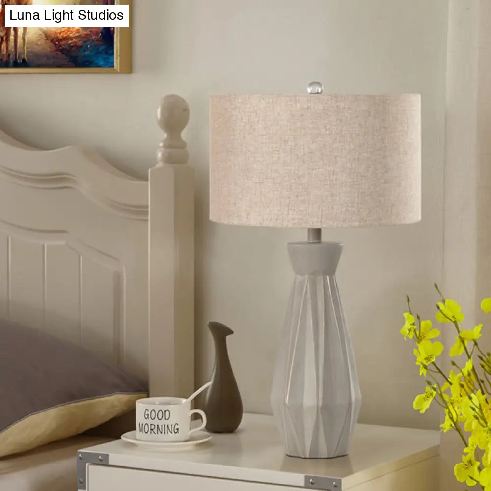Lámpara de mesa de noche rústica beige/blanca con pantalla cilíndrica de tela.
